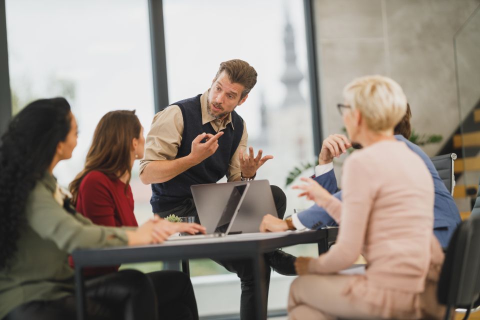A team talking around a table with laptops